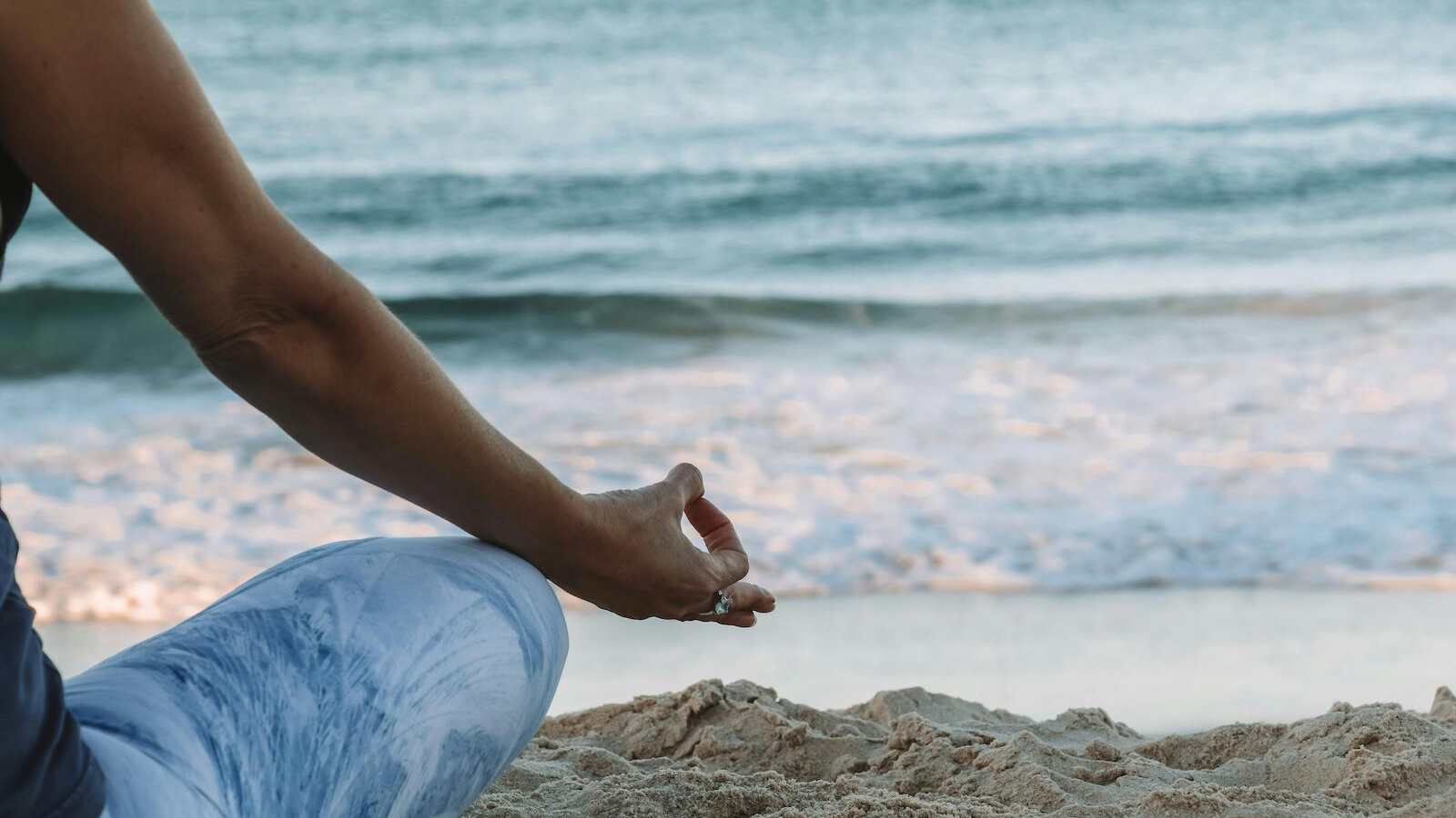 femme pratiquant une méditation somatique face à la mer pour se reconnecter aux sensations du corps