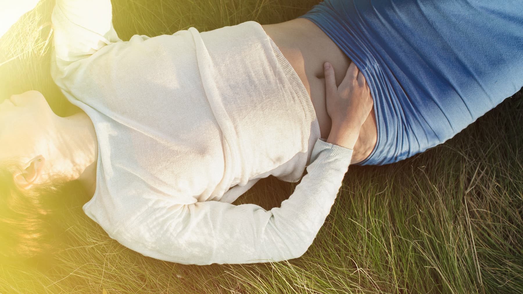 femme allongée main sur le ventre respiration pour réguler le système nerveux